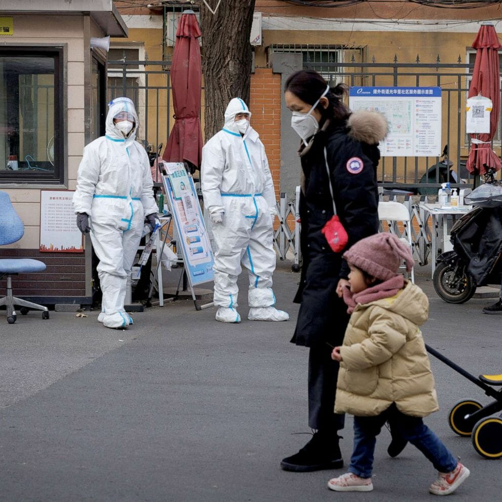 Guards in protective suits keep watch at the gate to a residential compound as coronavirus disease outbreaks continue in Beijing, Dec. 7, 2022.