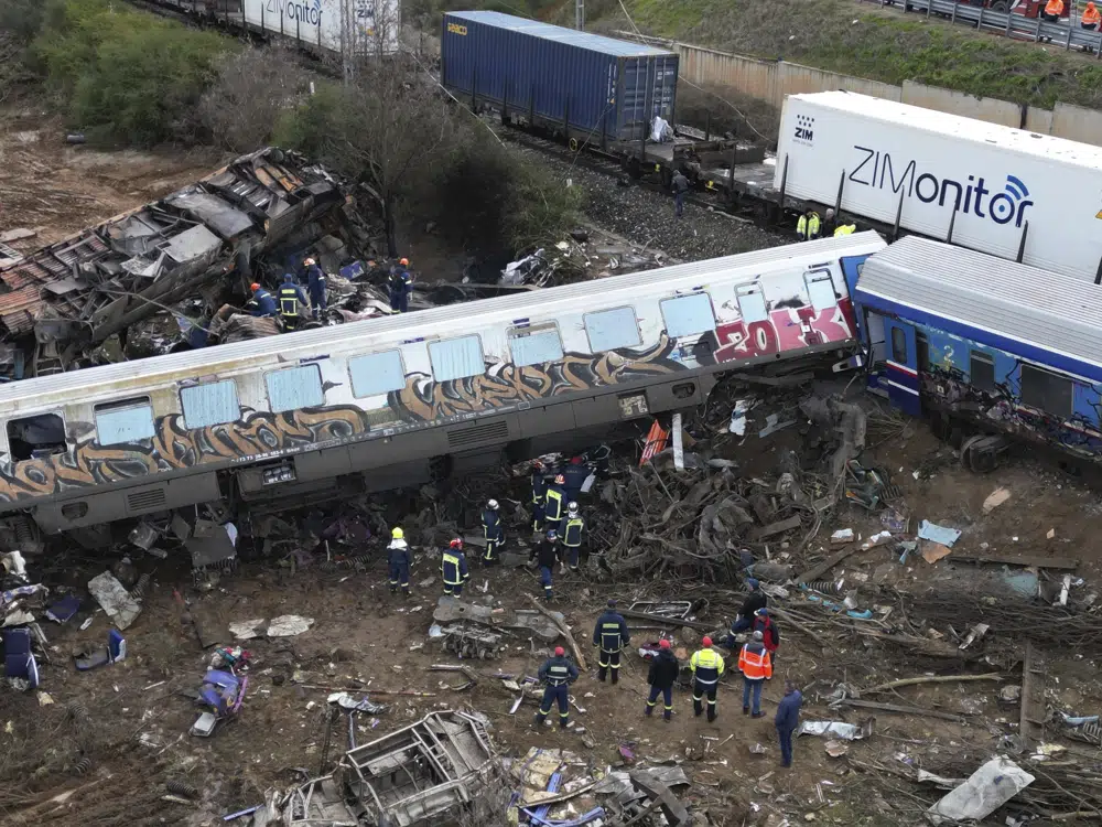 Firefighters and rescuers operate after a collision in Tempe near Larissa city, Greece, Wednesday, March 1, 2023. A train carrying hundreds of passengers has collided with an oncoming freight train in northern Greece, killing and injuring dozens passengers. (AP Photo/Vaggelis Kousioras)