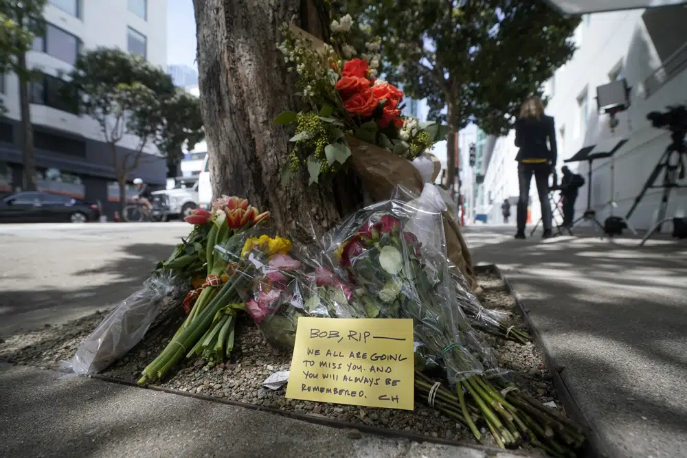 Flowers sit at a tree in front of the building where a technology executive was fatally stabbed outside of in San Francisco, Thursday, April 6, 2023. Details of how tech executive Bob Lee came to be fatally stabbed in downtown San Francisco early Tuesday were scarce as friends and family continued to mourn the man they called brilliant, kind and unlike others in the industry. (AP Photo/Jeff Chiu)
