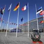An empty flagpole stands between the national flags of France and Estonia outside NATO headquarters in Brussels, Monday, April 3, 2023. Finland awaits an official green light to become the 31st member of the world's biggest security alliance as NATO foreign ministers prepare to meet in Brussels on Tuesday and Wednesday. (AP Photo/Virginia Mayo)